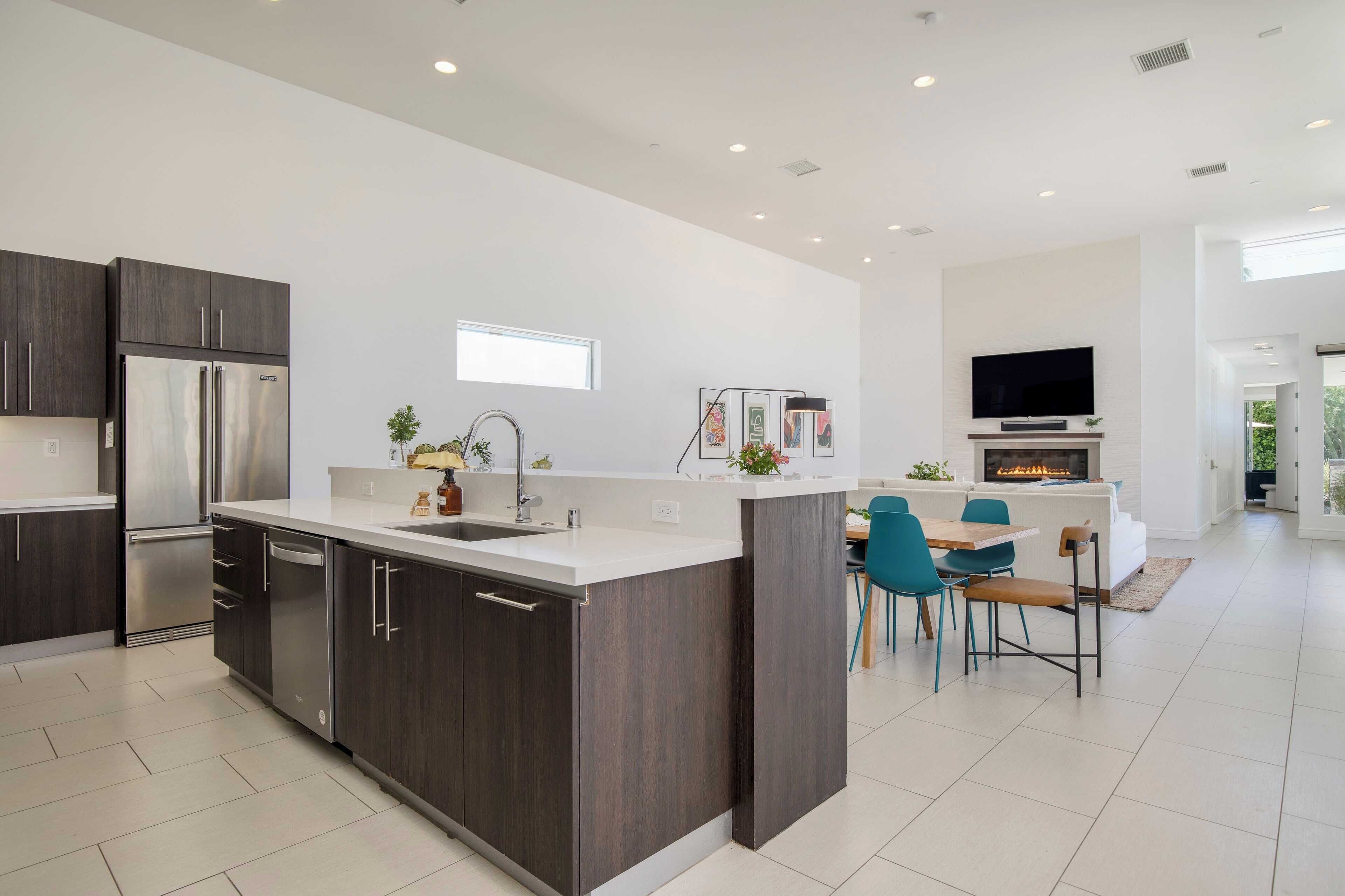 A modern kitchen with dark wood cabinets, stainless steel appliances, and a central island.