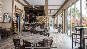 Ein geräumiges Restaurant mit hohen Decken, Holzböden und großen Fenstern, die einen Blick ins Freie bieten.