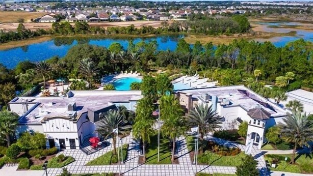 Ein Resort mit Schwimmbad, Palmen und Seeblick.