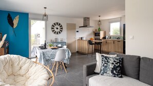 Un espace de vie moderne comprenant un coin repas, une cuisine et une grande fenêtre.