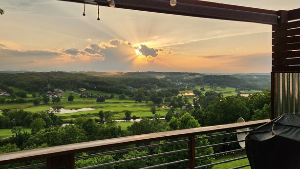 A view from a balcony overlooking a golf course with a sunset in the background. - Views of Osage Golf Course & Osage River, 3 Balconies, Game Room, Sleeps 9 (Kaiser)