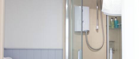 A bathroom with a toilet, sink, and a glass-enclosed shower stall.