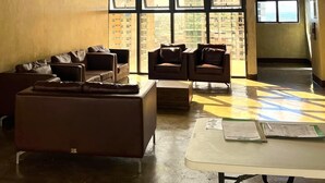 A spacious room with a large window, a ceiling fan, and a sofa.