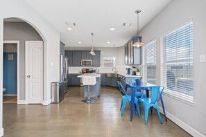 Enjoy meals in the central island kitchen with an oven, sink, and stainless steel refrigerator.