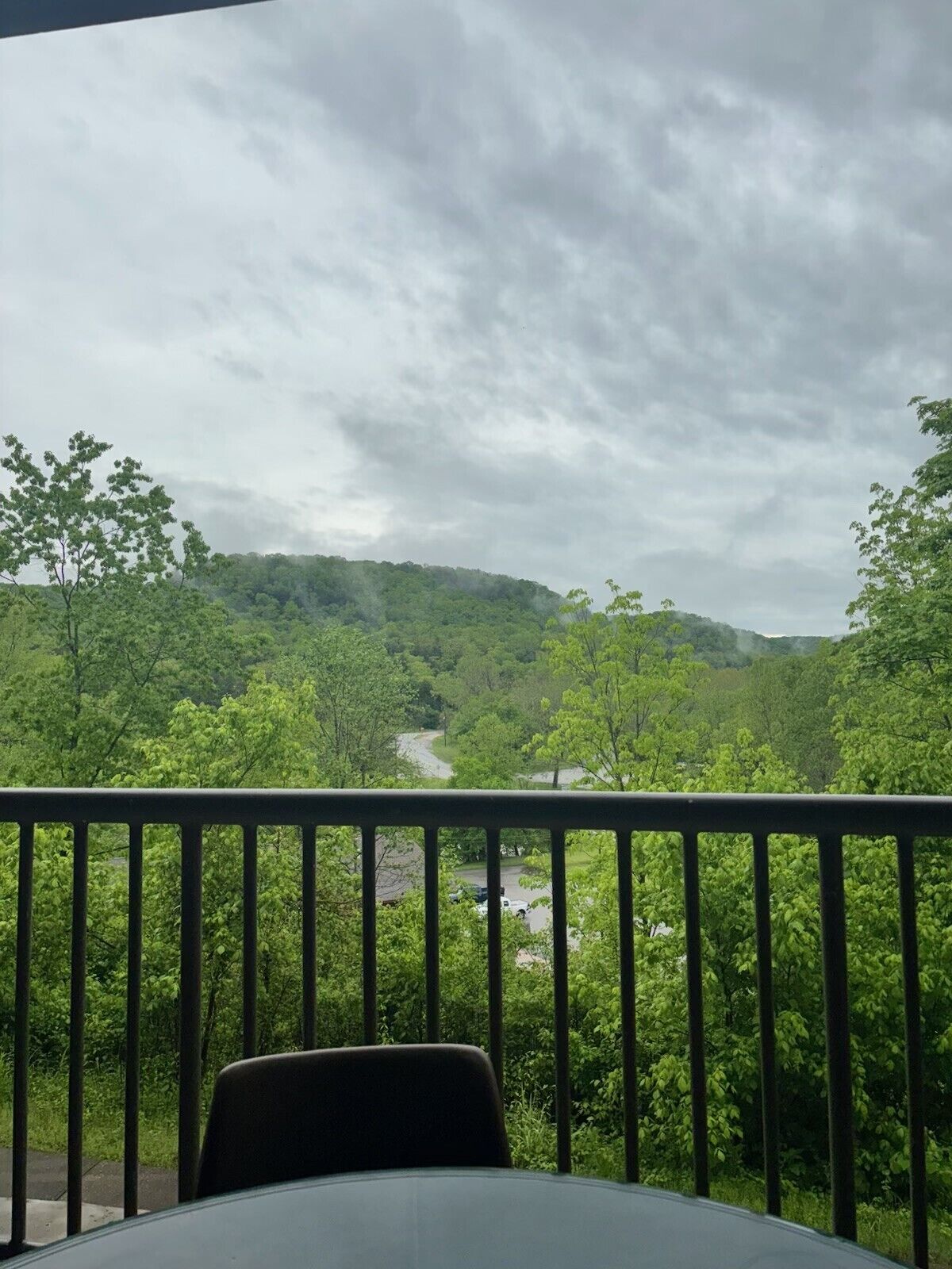 A balcony with a view of a valley and a road.