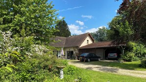 Ein Haus mit Garage, Garten und einem geparkten Auto.