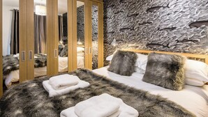 A bedroom with a large bed, fluffy pillows, and a wardrobe with mirrors. - 2 bedroom accommodation in Seahouses (Seahouses)