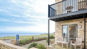 A stone building with a balcony overlooking a coastal view. - 2 bedroom accommodation in Seahouses (Seahouses)