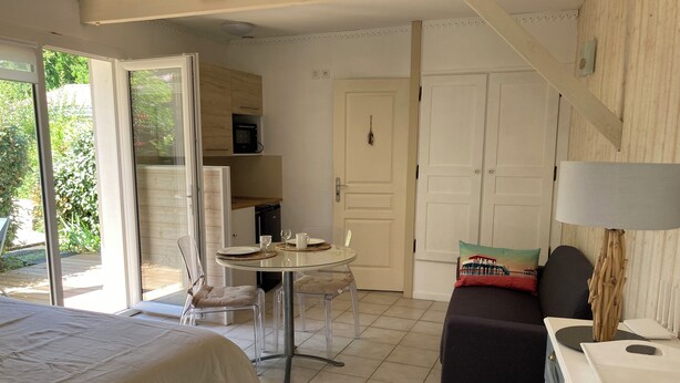 Ein Zimmer mit einem Bett, einem Tisch für zwei Personen, einer Couch und einer Lampe.