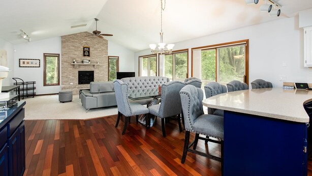 Amplia sala de estar con chimenea, comedor con una isla grande y cocina con un armario azul.