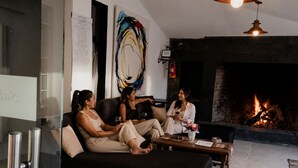 Una sala moderna con chimenea, un separador de vidrio y una obra de arte contemporánea.