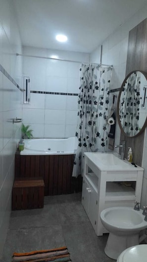 Un baño con bañera, lavamanos, bidé y espejo.