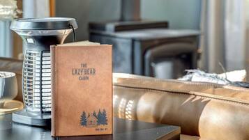 A book titled 'The Lazy Bear Cabin' on a table next to a black kettle.