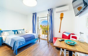 Relax in a serene bedroom with a large bed, wooden table, and a paddle mounted on the wall.