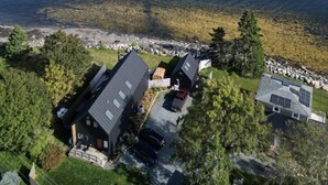 A coastal property with two main buildings, a parking area, and a view of the sea. - Zen Oceanfront Chalet- Hot Tub & Sauna -  Private (South Shore)