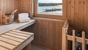 Un sauna en bois, avec un banc, une serviette et un seau.