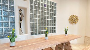A wooden bench with potted cacti and a decorative wall with a mosaic pattern.