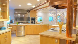 A modern kitchen with wooden cabinets, stainless steel appliances, and a central island.