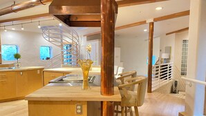 A modern kitchen with wooden cabinets, a central island, and a copper column.