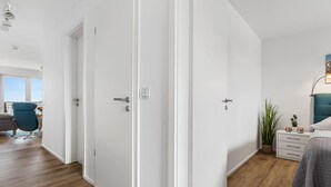 A modern bedroom with a bed, bedside table, lamp, and a view of the outdoors. - Nice apartment in Olpenitz with WiFi (Olpenitz)