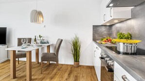 A modern kitchen with a dining area, wooden flooring, and a potted plant. - Nice apartment in Olpenitz with WiFi (Olpenitz)