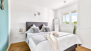 A bedroom with a bed, a window, and a wall decoration. - Cozy apartment in Olpenitz (Olpenitz)