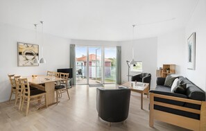 Relax in a stylish living space with a dining area, comfortable seating, and a balcony offering a neighborhood view.