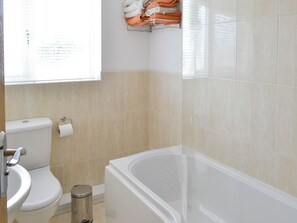 Une salle de bain avec des toilettes, un lavabo et une baignoire.
