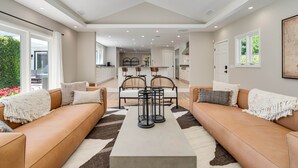 A modern living room with a sofa set, a coffee table, and a dining area with chairs. - Large Quiet Sonoma Oasis with Pool (Sonoma)
