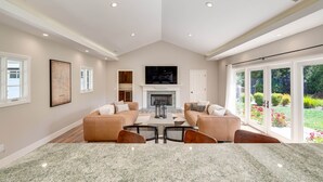A spacious living room with a fireplace, two sofas, a coffee table, and a TV. - Large Quiet Sonoma Oasis with Pool (Sonoma)