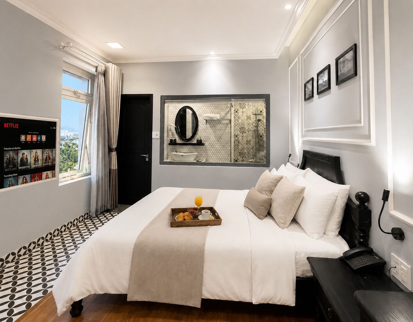 A hotel room with a bed, bedside table, and a wall-mounted TV displaying Netflix content.