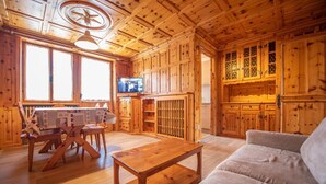 A wooden cabin interior with a dining area, sofa, and kitchen cabinets. - Be won over by the Valente two-room apartment and enjoy your vacation (Livigno)