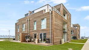 A modern two-story building with a flat roof, large windows, and a balcony. - Lovely apartment in Olpenitz with sauna (Olpenitz)