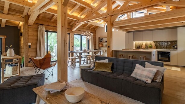 A spacious wooden interior with a dining area, kitchen, and seating area. - MAISON ORIGINE - BEAUFORT (BEAUFORT)