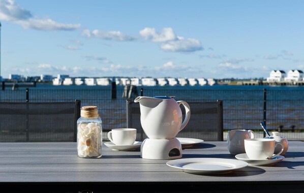 Enjoy a serene outdoor dining experience with a breathtaking view overlooking the water.