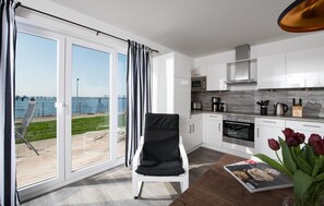 Relax in this serene space with a sliding door leading to an outdoor area, a dining table, and a fully equipped kitchen.