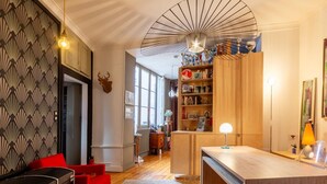 Un salon moderne avec une table basse en bois, des canapés rouges et un mur orné de motifs.