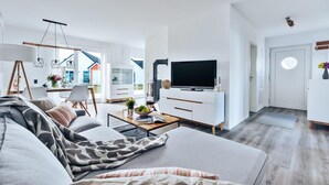 Een moderne woonkamer met een bank, salontafel en een flatscreen televisie.