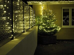 Un edificio con una valla decorativa y un árbol de Navidad.