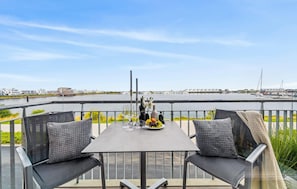 Enjoy a romantic dinner for two on this waterfront terrace with a table set amidst a serene marina and beautiful views.