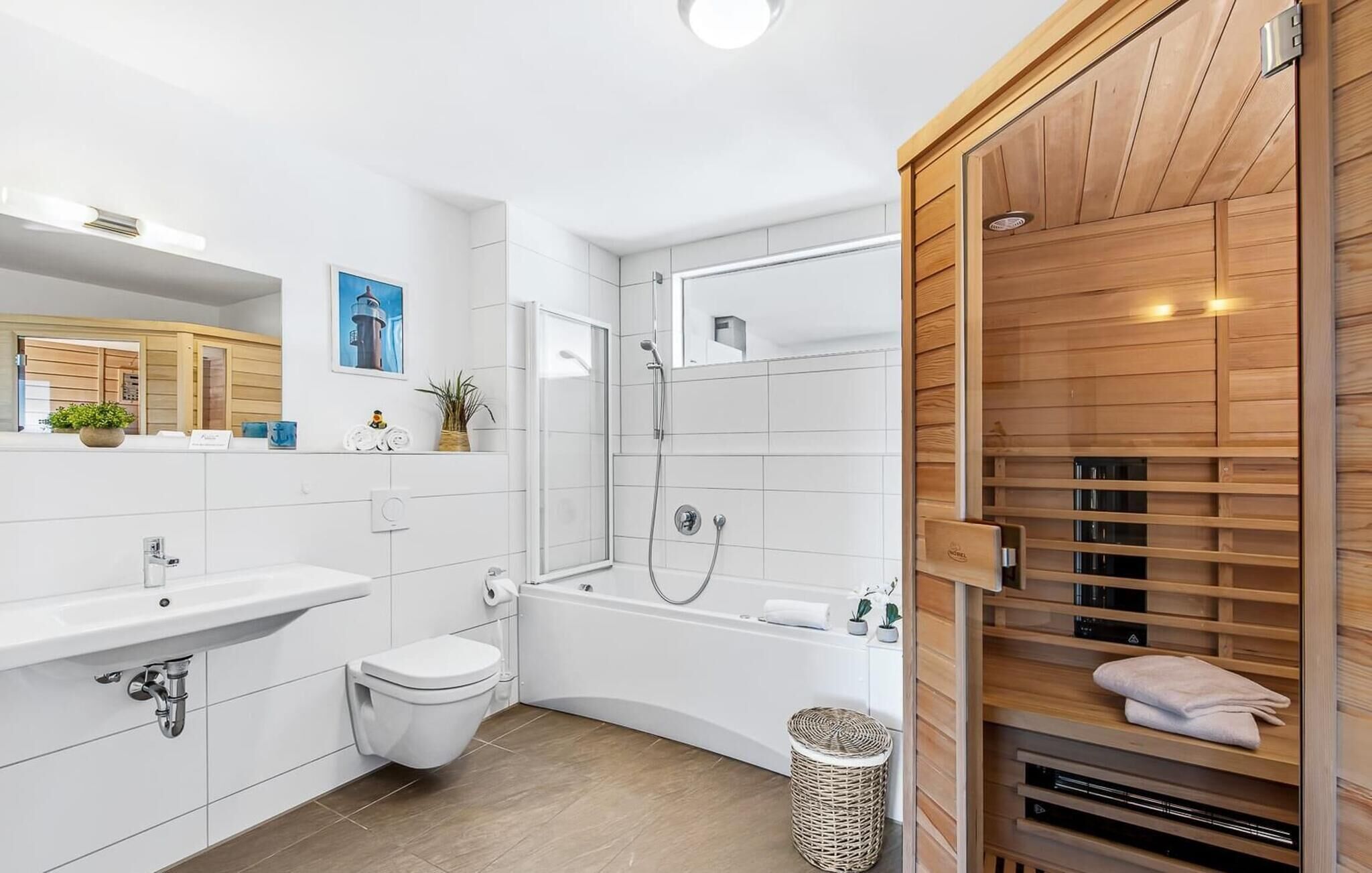 Ein modernes Badezimmer mit einem weißen Waschbecken, einer Toilette und einer Badewanne. Eine Wandpaneele aus Holz und ein kleiner Korbwannenkorb befinden sich auf dem Boden.