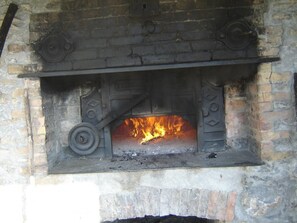 Cozy warmth is provided by the traditional fireplace, built into a brick wall with decorative metal accents.