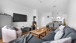 Ein modernes Wohnzimmer mit einer Couch, einem Couchtisch und einem Kamin.