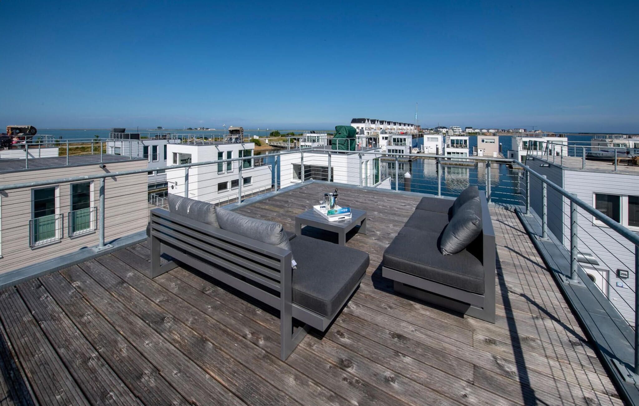 A rooftop deck with a modern outdoor seating area, a pool, and a view of the cityscape.