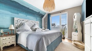 A bedroom with a large bed, a nightstand, a dresser, and a large window with a view of the city. - Gorgeous apartment in Olpenitz (Olpenitz)