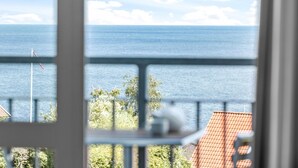 Un balcon avec vue sur la mer et un drapeau.