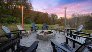 Un espace extérieur aménagé avec des chaises Adirondack et un foyer.