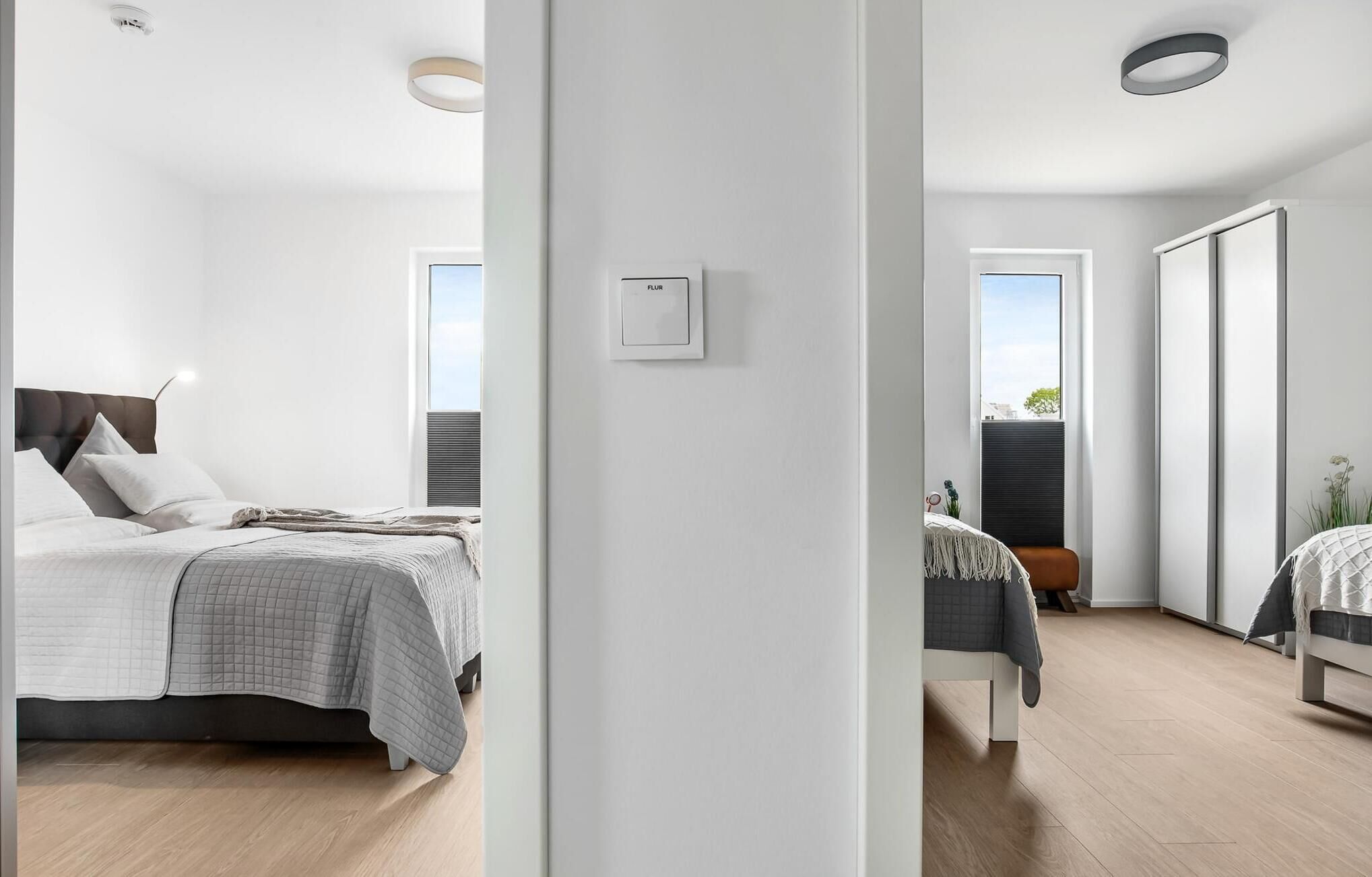 Une chambre moderne avec un lit, une table de chevet et une vue sur l’extérieur.