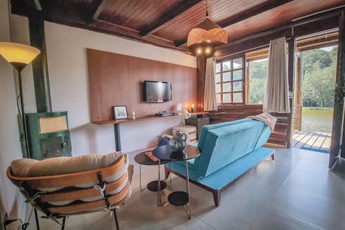 Quarto luxo, 2 quartos, banheira de hidromassagem, vista para a lagoa | Área de estar | TV de tela plana 42 polegadas com canais a cabo, brinquedos