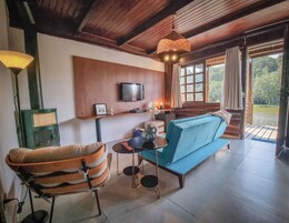 Una sala de estar acogedora con un sofá azul, techo de madera, televisor y chimenea.